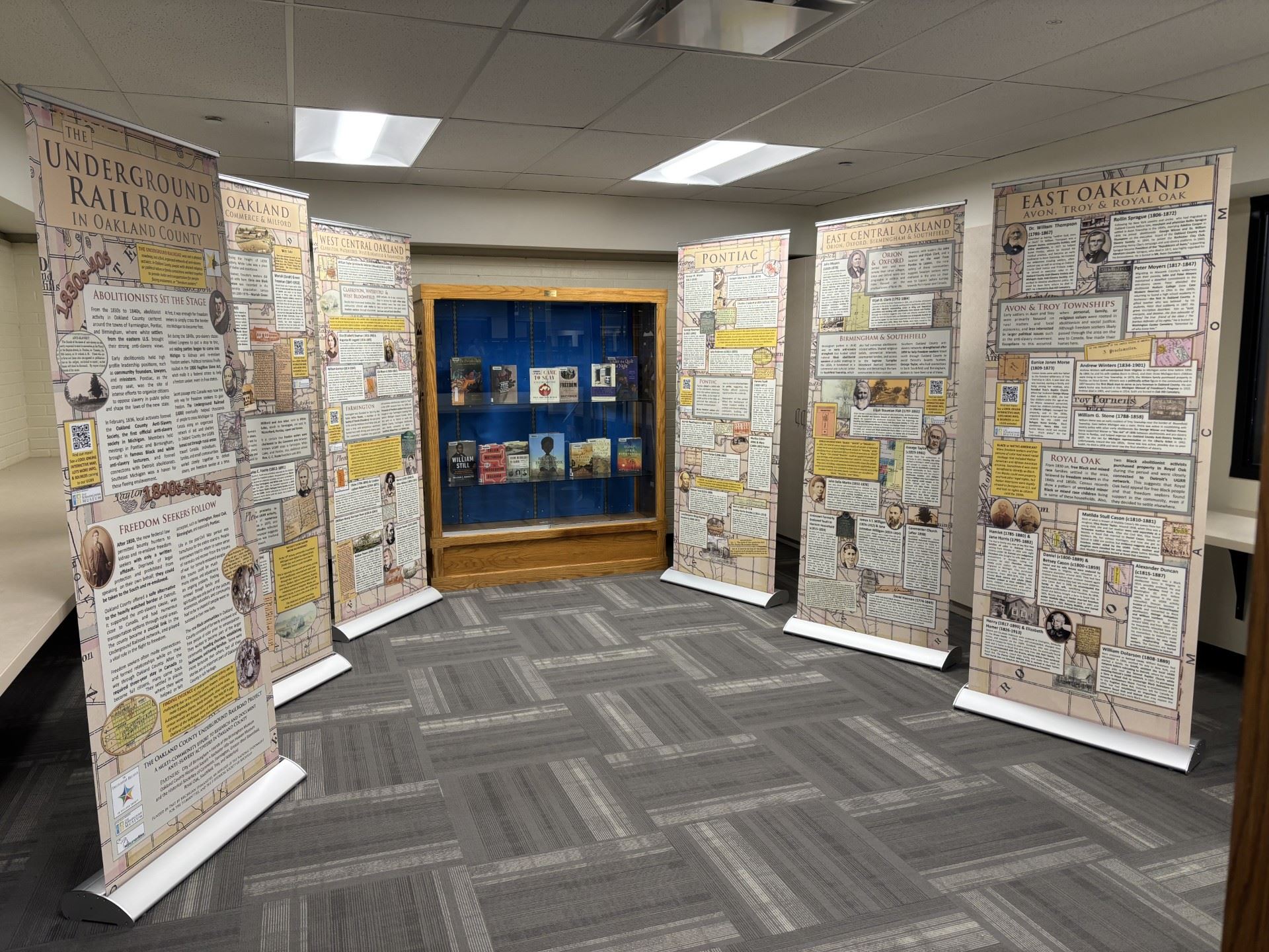 Six panels with a timeline of underground railroad history along with a book display